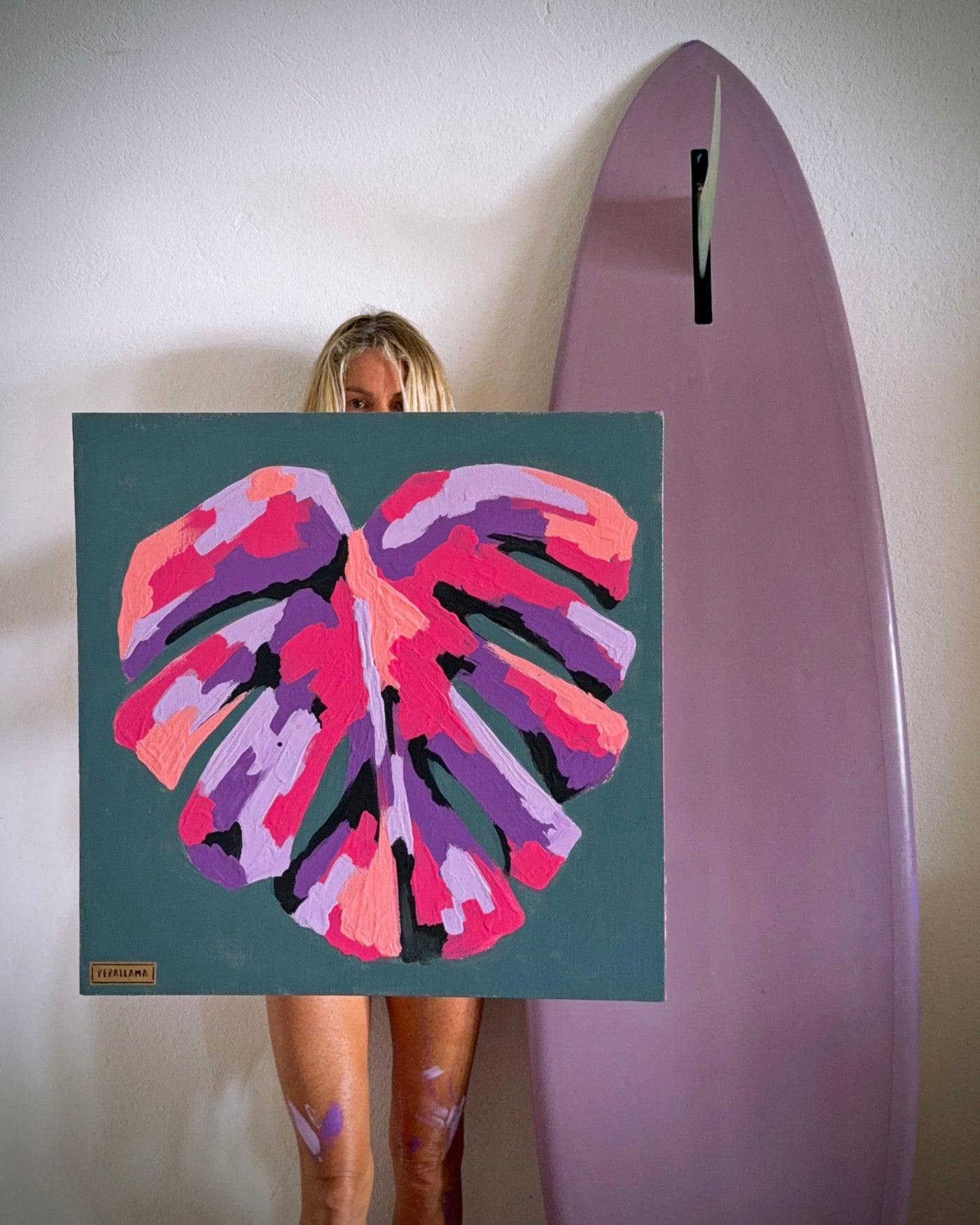 artist and surfer pepallama with a monstera leaf painting in her Costa Rica studio