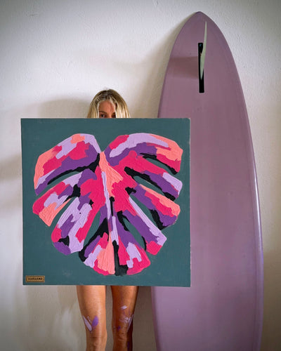 artist and surfer pepallama with a monstera leaf painting in her Costa Rica studio