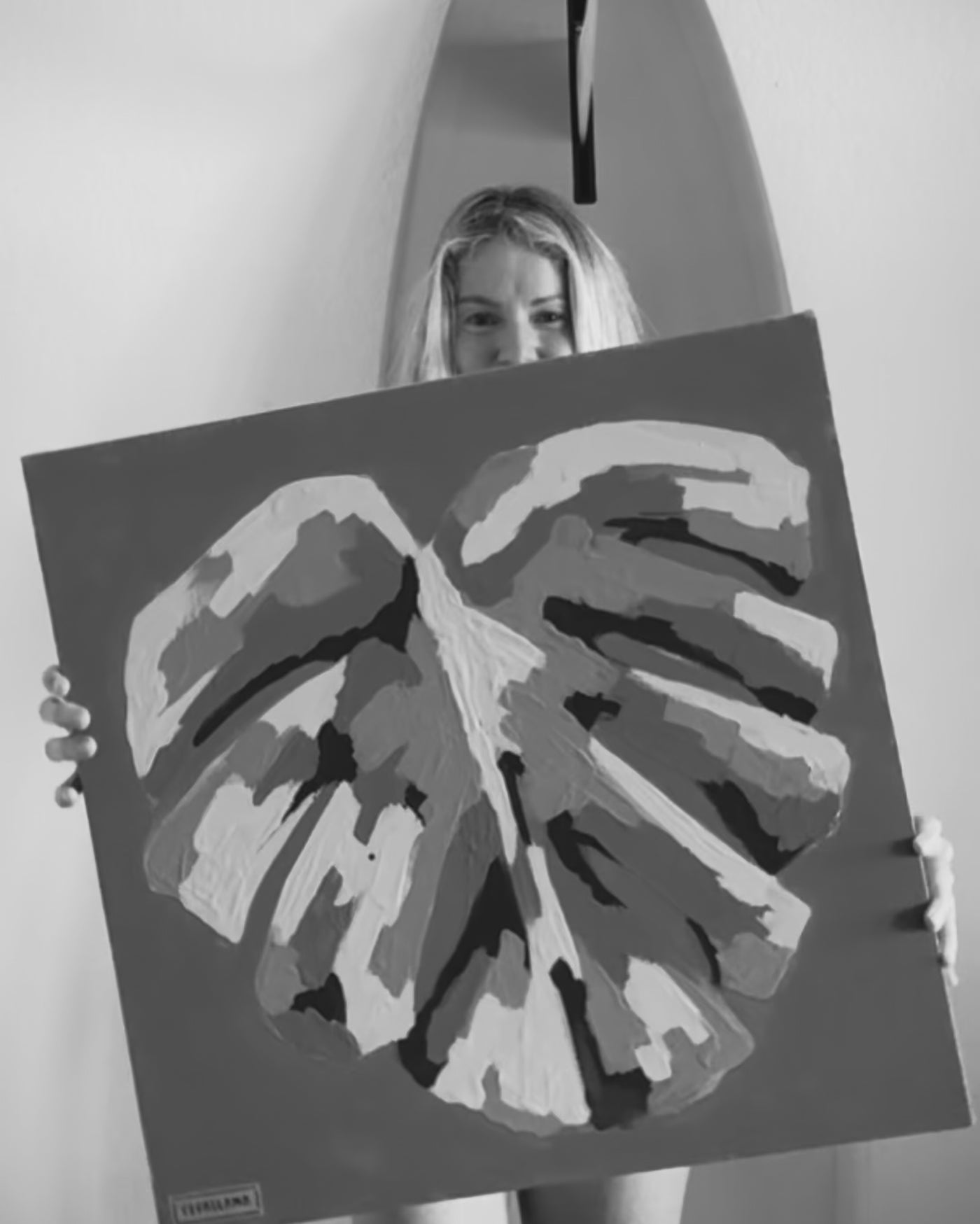 artist pepallama hand painting an original on canvas, featuring a tropical monstera leaf and bright colour palette