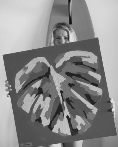 artist pepallama hand painting an original on canvas, featuring a tropical monstera leaf and bright colour palette